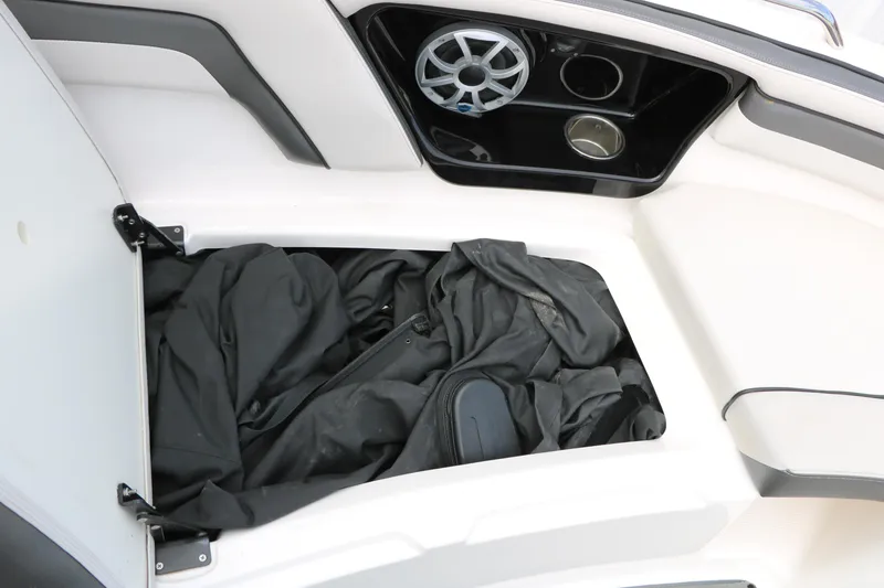 Slide: The Image of Open storage compartment in 2017 Yamaha AR240 HO boat with black fabric inside. - 44
