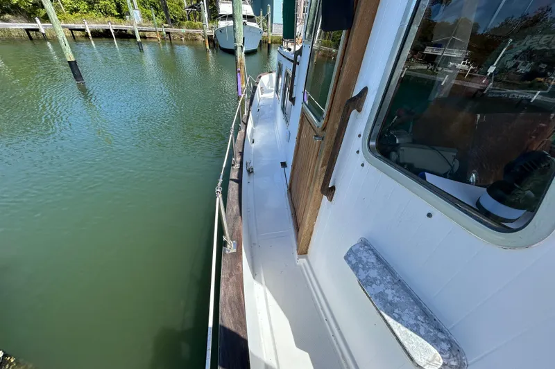 Slide: The Image of 1987 Transpacific Marine Eagle 32 Trawler docked, showcasing side deck and cabin details. - 5