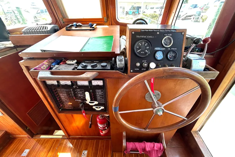 Slide: The Image of 1987 Transpacific Marine Eagle 32 Trawler helm with gauges, controls, and wooden steering wheel. - 35