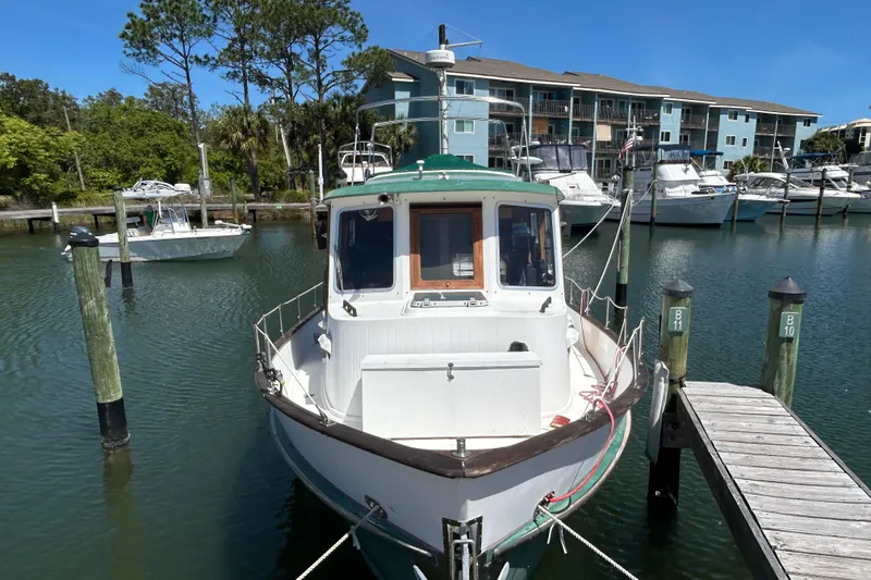 Slide: The Image of 1987 Transpacific Marine Trawler docked at marina, surrounded by other boats and waterfront buildings. - 1