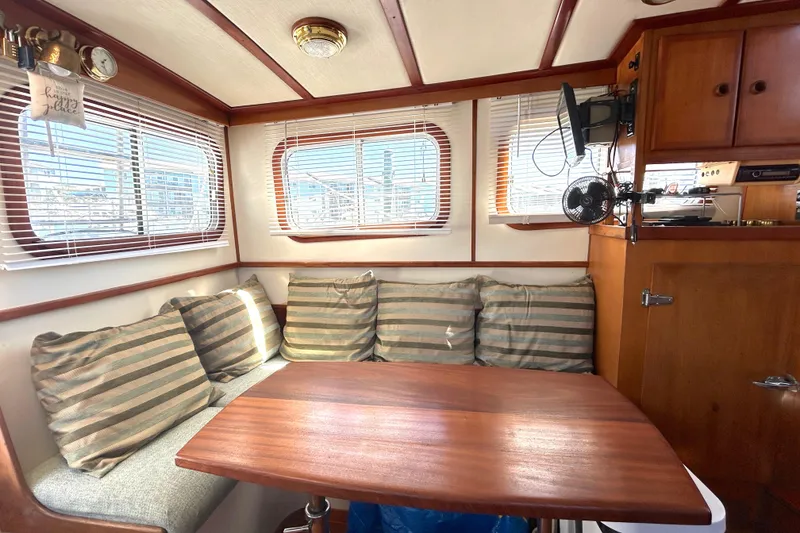 Slide: The Image of Cozy interior of 1987 Transpacific Marine Eagle 32 Trawler with striped cushions and wooden table. - 24