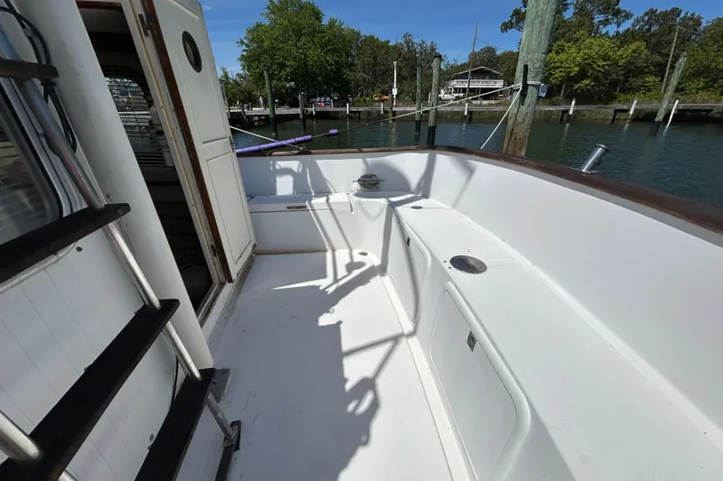 Slide: The Image of 1987 Transpacific Marine Eagle 32 Trawler deck with open cabin door, docked by the water. - 11