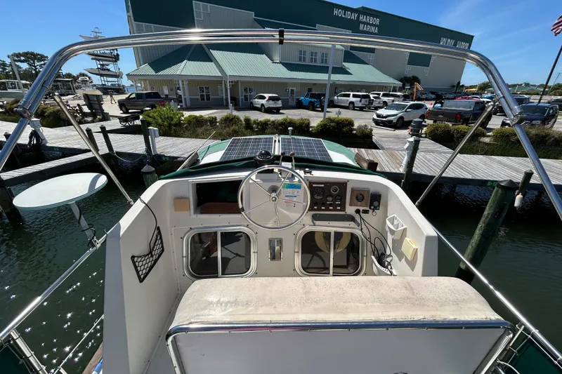Slide: The Image of 1987 Transpacific Marine Eagle 32 Trawler at marina dock, featuring helm and solar panels. - 17