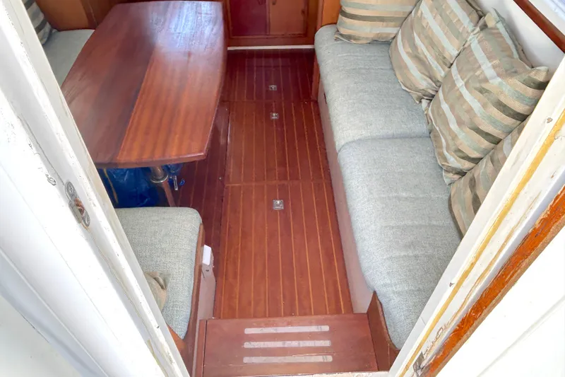 Slide: The Image of Interior of 1987 Transpacific Marine Eagle 32 Trawler with wooden table and cushioned seating. - 20
