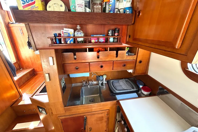 Slide: The Image of 1987 Transpacific Marine Eagle 32 Trawler galley with wooden cabinetry and compact sink area. - 28