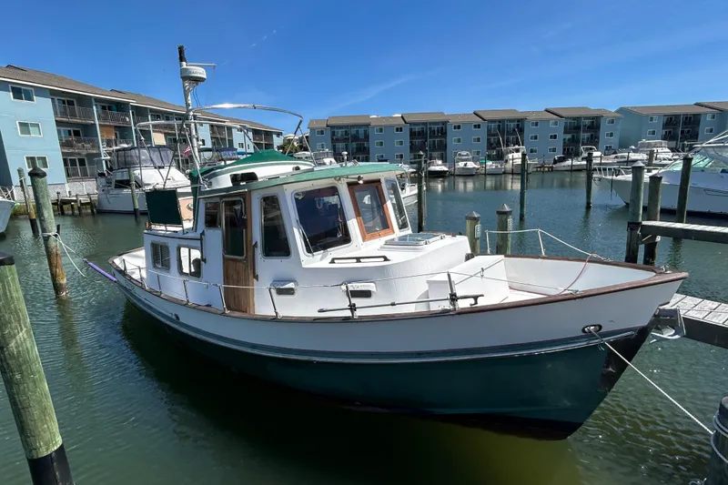 Slide: The Image of 1987 Transpacific Marine Trawler docked at marina with waterfront apartments in background. - 3