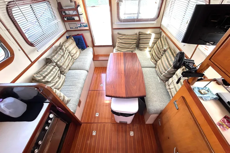 Slide: The Image of Interior of 1987 Transpacific Marine Eagle 32 Trawler with cozy seating and wooden table. - 32