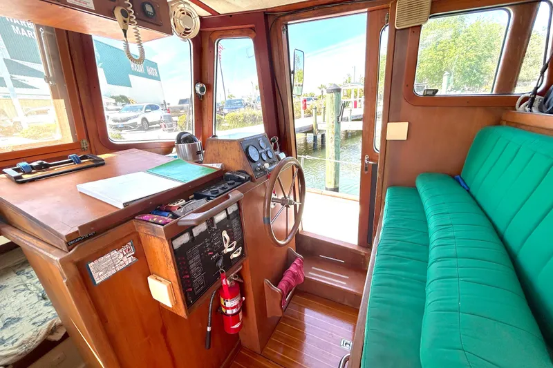 Slide: The Image of 1987 Transpacific Marine Eagle 32 Trawler interior with helm, green seating, and wooden accents. - 34