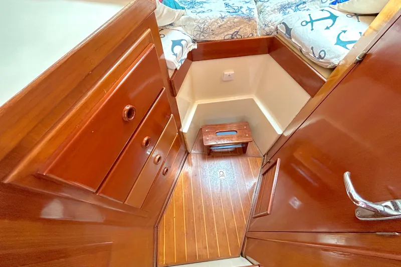 Slide: The Image of Interior of 1987 Transpacific Marine Eagle 32 Trawler with wooden cabinetry and nautical-themed bedding. - 42