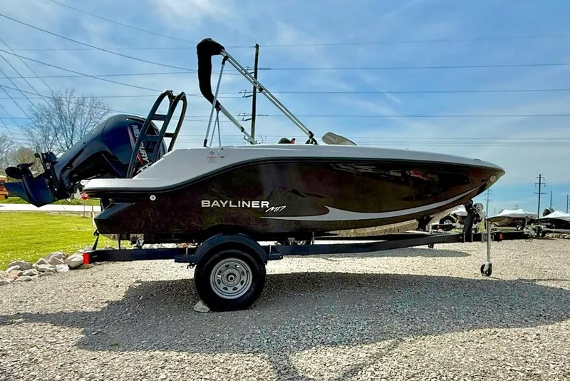 The Image of 2026 Bayliner M17 boat on trailer, parked outdoors under clear sky. - 1