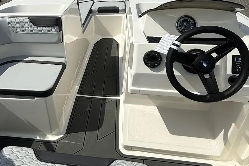 Slide: The Image of 2026 Bayliner M17 boat interior with steering wheel and seating area. - 7