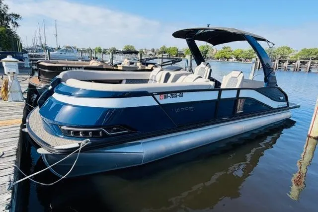 Slide: The Image of 2022 Harris Grand Mariner 250 pontoon boat docked at a marina. - 1