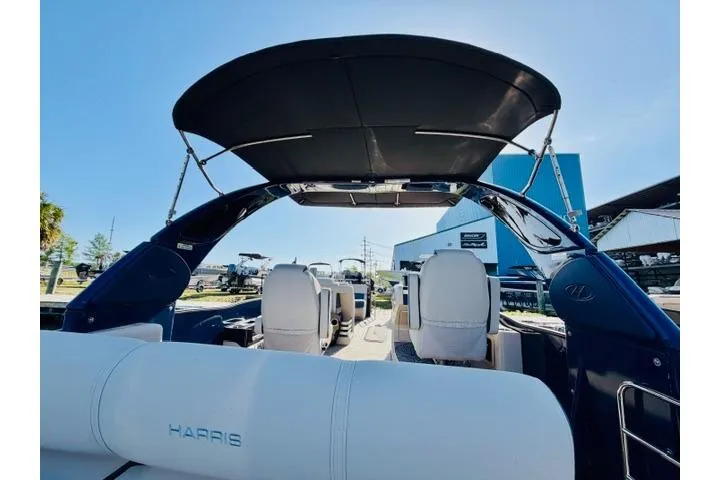 Slide: The Image of 2022 Harris Grand Mariner 250 boat interior with canopy and seating, under clear blue sky. - 12