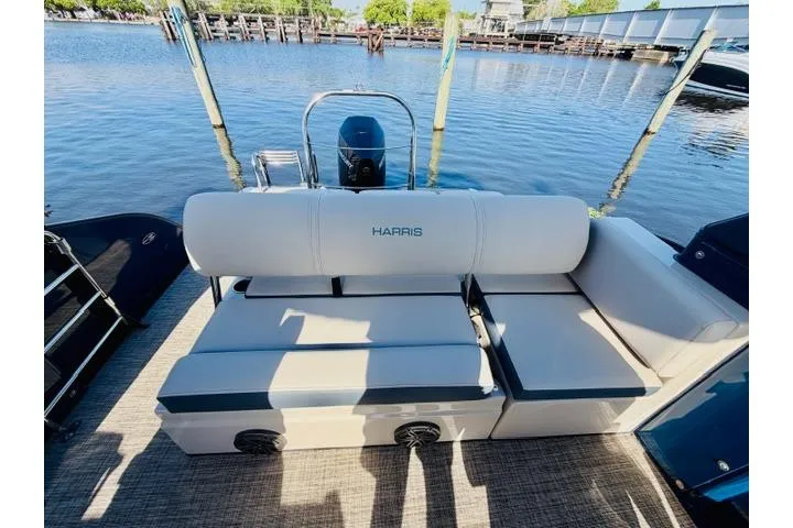Slide: The Image of 2022 Harris Grand Mariner 250 boat with plush seating by the water. - 7