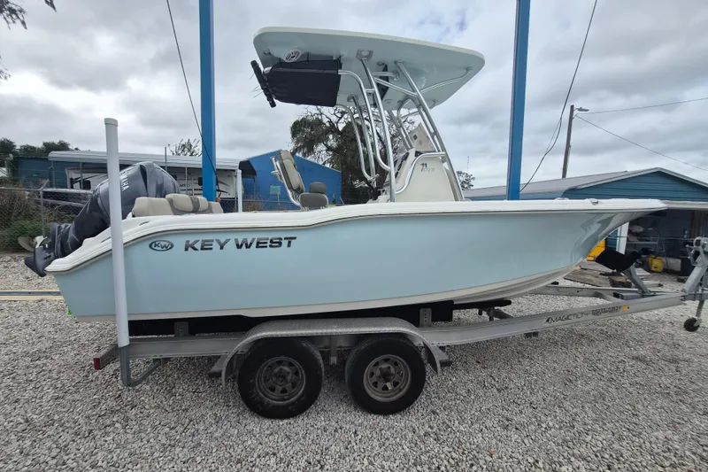 The Image of 2026 Key West 219 FS boat on trailer, light blue hull, overcast sky background. - 1
