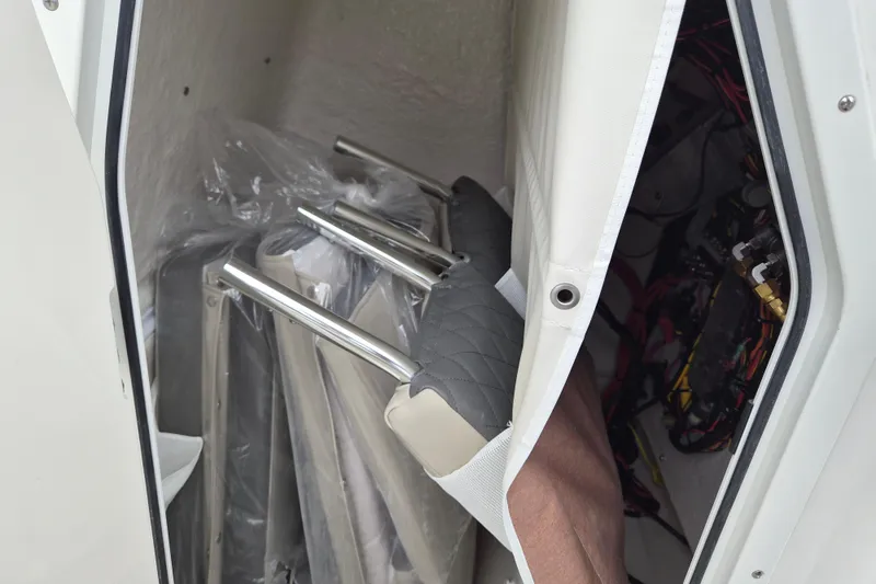 Slide: The Image of Storage compartment in a 2026 Key West 219 FS boat with seat cushions and metal frames. - 16