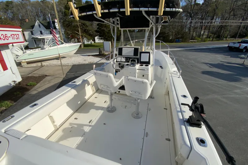 Slide: The Image of 2000 Boston Whaler 26 Outrage boat interior with helm and seating, parked outdoors. - 11