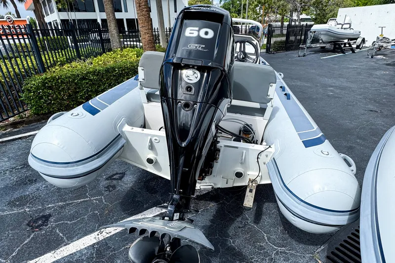 Slide: The Image of 2024 Highfield Classic 420 inflatable boat with a 60 HP outboard motor, parked outdoors. - 5