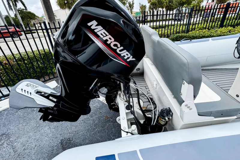 Slide: The Image of 2024 Highfield Classic 420 boat with Mercury outboard motor, docked near a fence. - 6