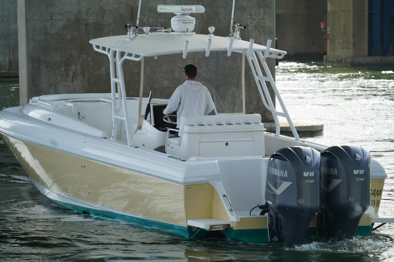 Slide: The Image of 2003 Intrepid 370 Cuddy boat with dual Yamaha V8 engines navigating under a bridge. - 10