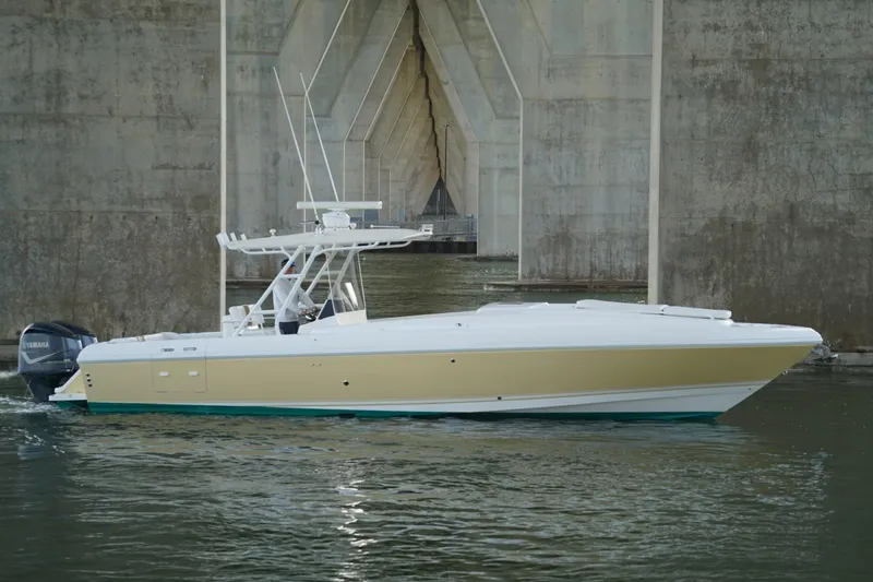 Slide: The Image of 2003 Intrepid 370 Cuddy boat cruising under a concrete bridge. - 13