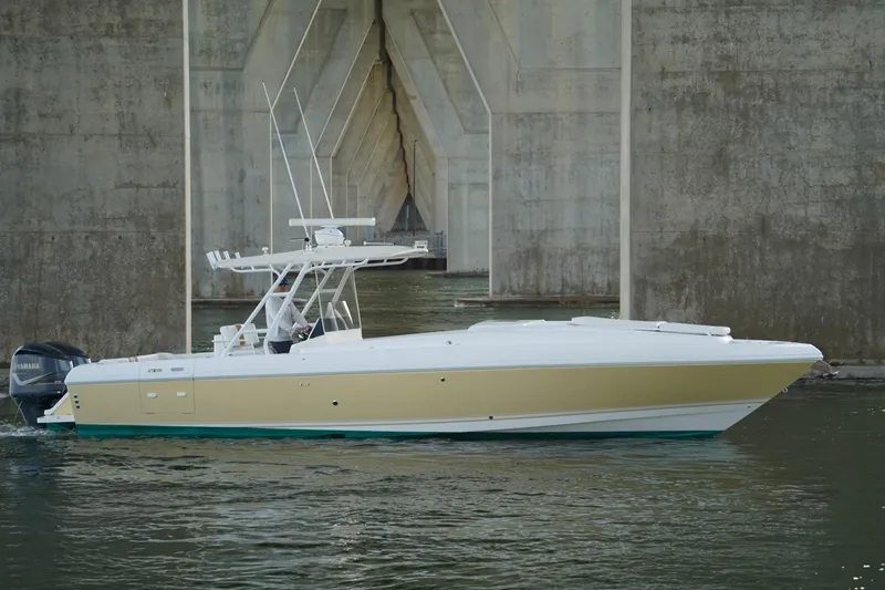 Slide: The Image of 2003 Intrepid 370 Cuddy boat cruising under a concrete bridge. - 14