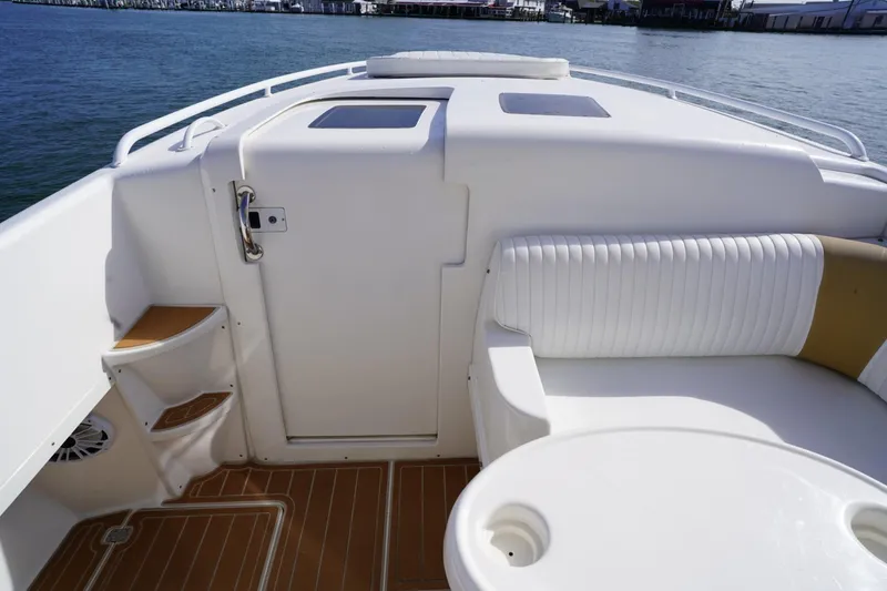 Slide: The Image of 2003 Intrepid 370 Cuddy boat interior with white seating and wooden flooring. - 15