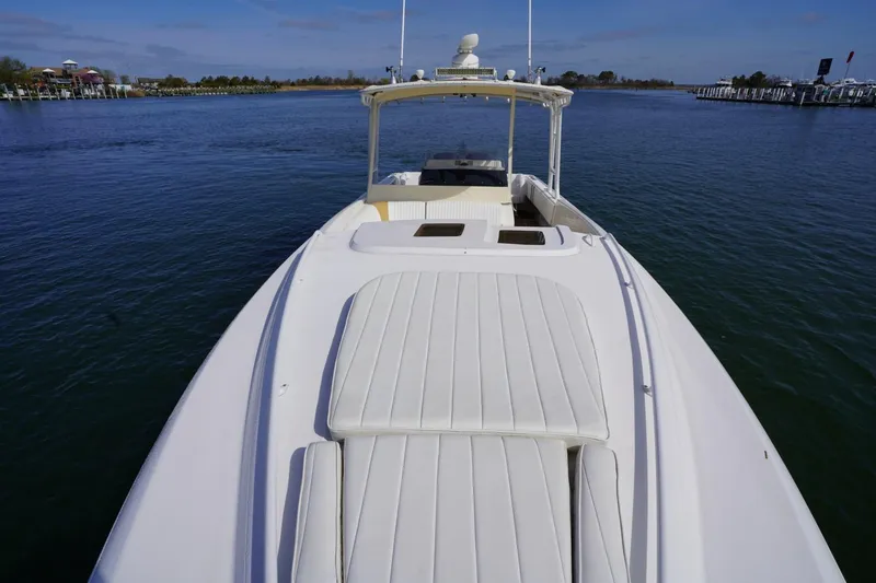 Slide: The Image of 2003 Intrepid 370 Cuddy boat on calm water, showcasing sleek design and spacious deck. - 16