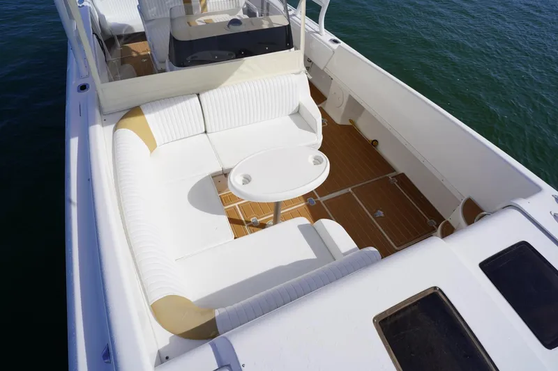 Slide: The Image of 2003 Intrepid 370 Cuddy boat interior with white seating and wooden deck. - 17
