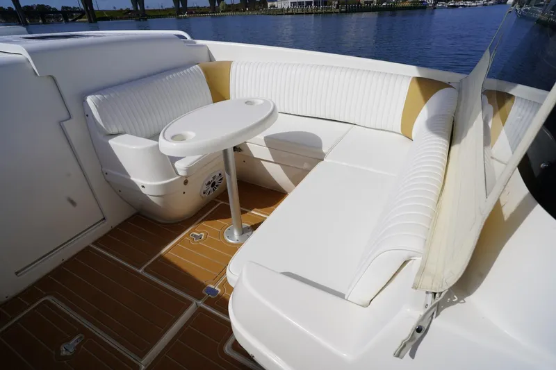 Slide: The Image of 2003 Intrepid 370 Cuddy boat interior with white seating and round table. - 22