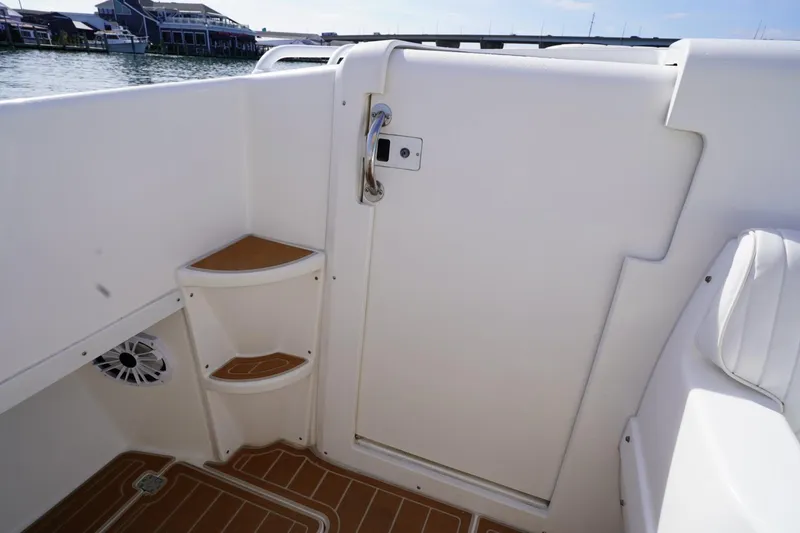 Slide: The Image of 2003 Intrepid 370 Cuddy boat interior with white seating and storage shelves. - 24