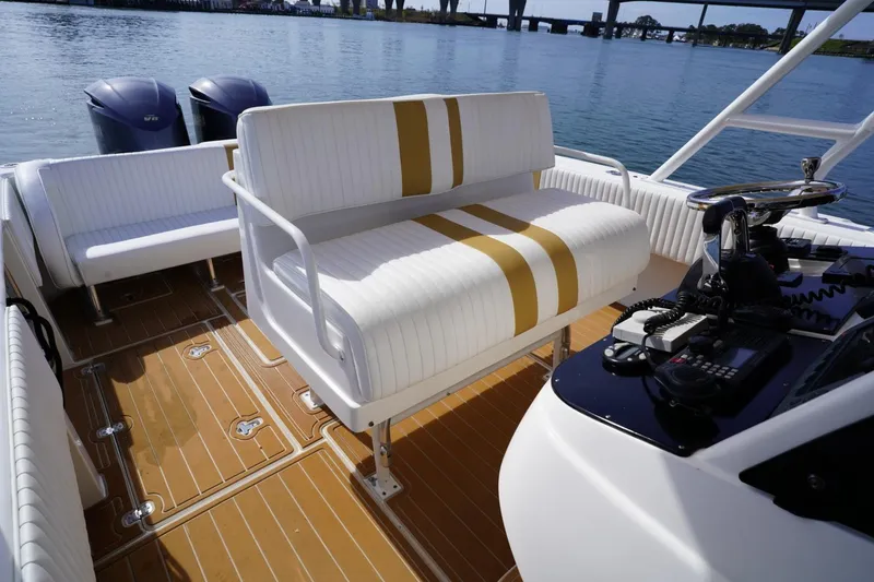 Slide: The Image of 2003 Intrepid 370 Cuddy boat interior with seating and control panel on water. - 26