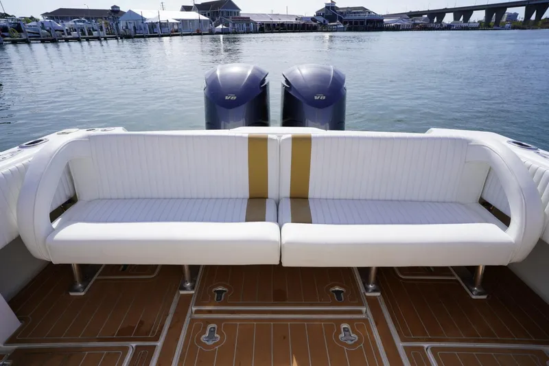 Slide: The Image of 2003 Intrepid 370 Cuddy boat with white seating and twin engines on water. - 28