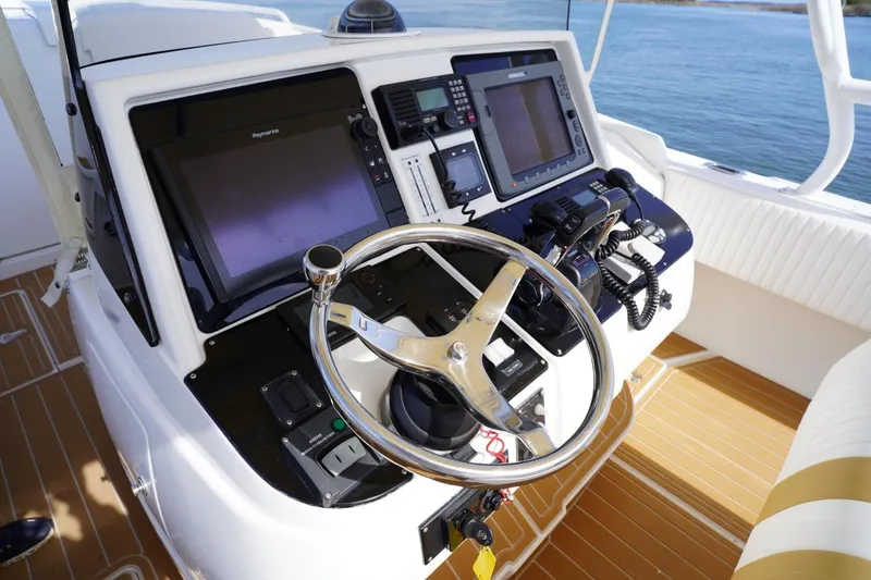 Slide: The Image of Helm of 2003 Intrepid 370 Cuddy boat with advanced navigation equipment and steering wheel. - 29