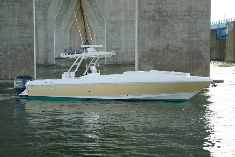 Slide: The Image of 2003 Intrepid 370 Cuddy boat cruising under a bridge on calm water. - 5