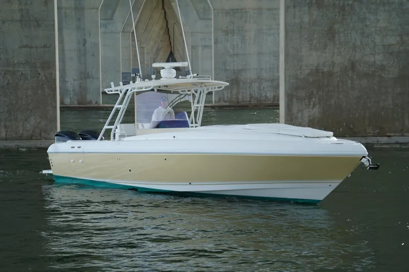 Slide: The Image of 2003 Intrepid 370 Cuddy boat navigating under a bridge on calm water. - 6