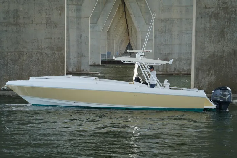 Slide: The Image of 2003 Intrepid 370 Cuddy boat cruising under a bridge with Yamaha engines. - 8