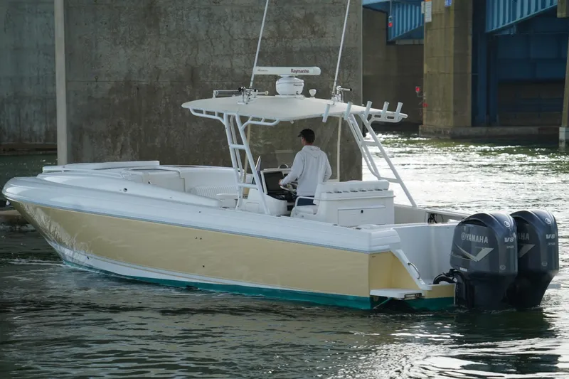 Slide: The Image of 2003 Intrepid 370 Cuddy boat with dual Yamaha engines navigating under a bridge. - 9