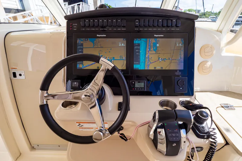 Slide: The Image of Helm of 2019 Boston Whaler 350 Realm with dual Raymarine displays and modern controls. - 10