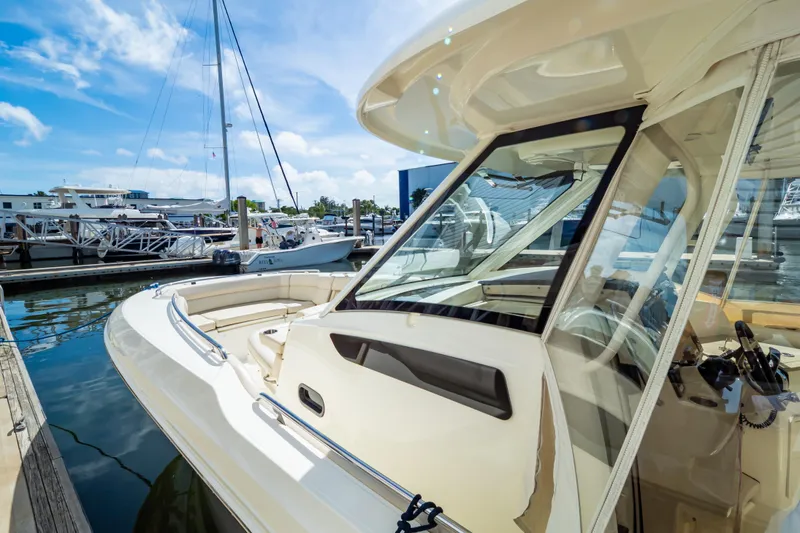 Slide: The Image of 2019 Boston Whaler 350 Realm docked at marina under clear blue sky. - 105
