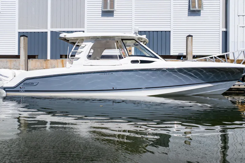 Slide: The Image of 2019 Boston Whaler 350 Realm boat docked by a marina. - 24