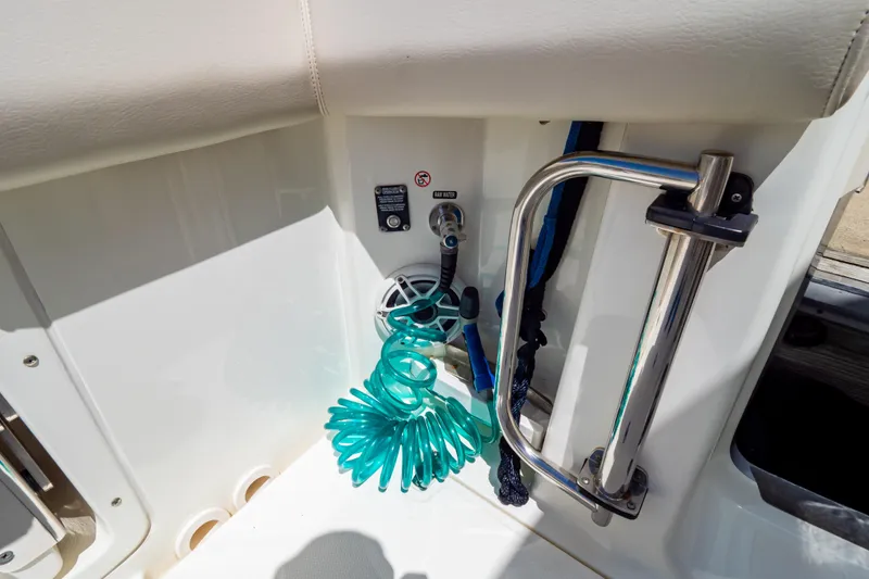 Slide: The Image of 2019 Boston Whaler 350 Realm boat interior with coiled hose and stainless steel rail. - 49