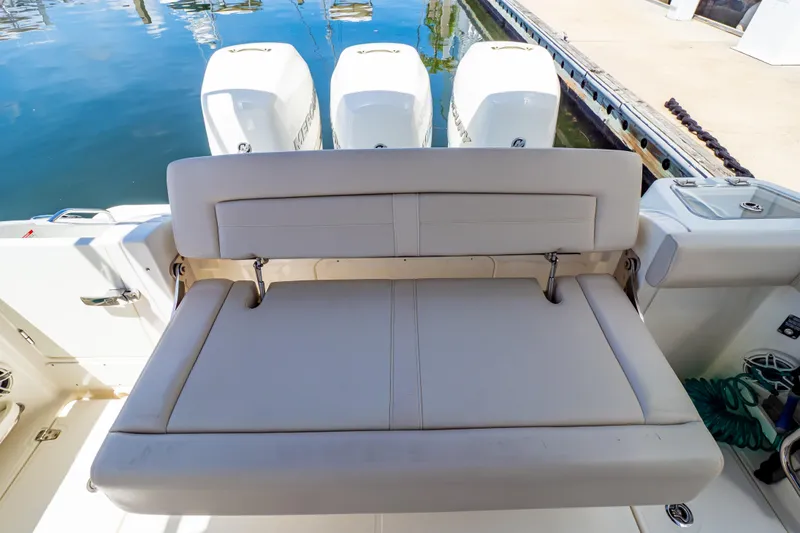Slide: The Image of 2019 Boston Whaler 350 Realm boat with cushioned seating and triple outboard engines. - 58