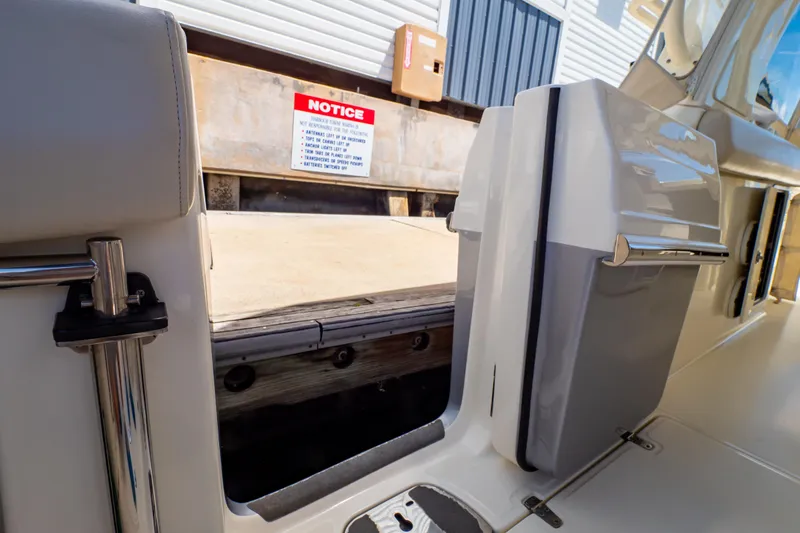 Slide: The Image of 2019 Boston Whaler 350 Realm boat interior with open door and dock view. - 61