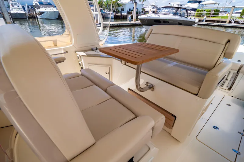 Slide: The Image of Interior of 2019 Boston Whaler 350 Realm with beige seating and wooden table. - 68