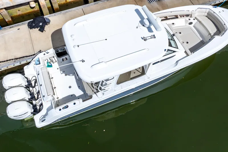 Slide: The Image of 2019 Boston Whaler 350 Realm boat docked, aerial view, featuring triple Mercury engines. - 7