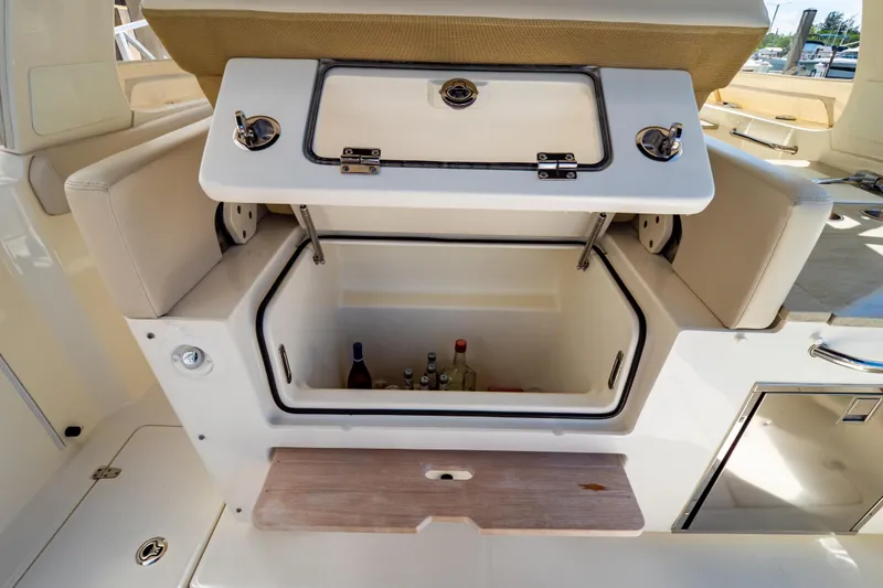 Slide: The Image of Open storage compartment on 2019 Boston Whaler 350 Realm boat, containing bottles. - 77