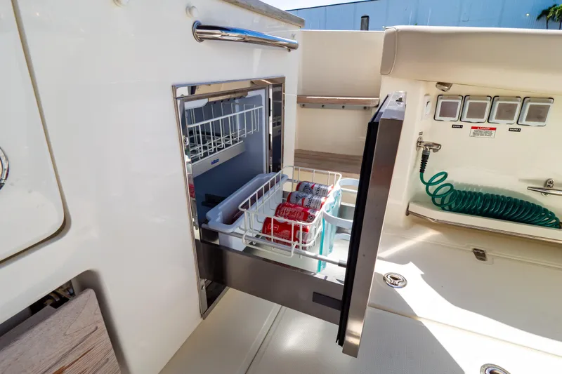 Slide: The Image of 2019 Boston Whaler 350 Realm boat with open drawer refrigerator, storing canned drinks. - 79