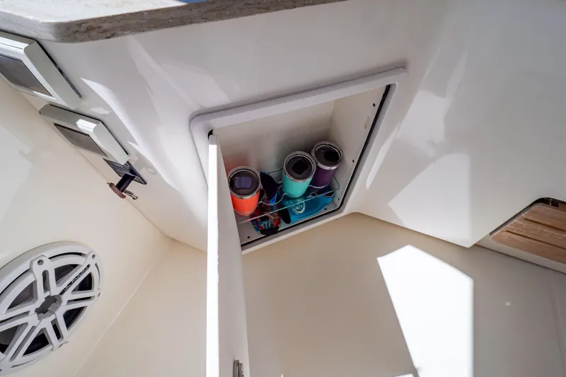 Slide: The Image of Storage compartment on 2019 Boston Whaler 350 Realm boat with colorful tumblers inside. - 93