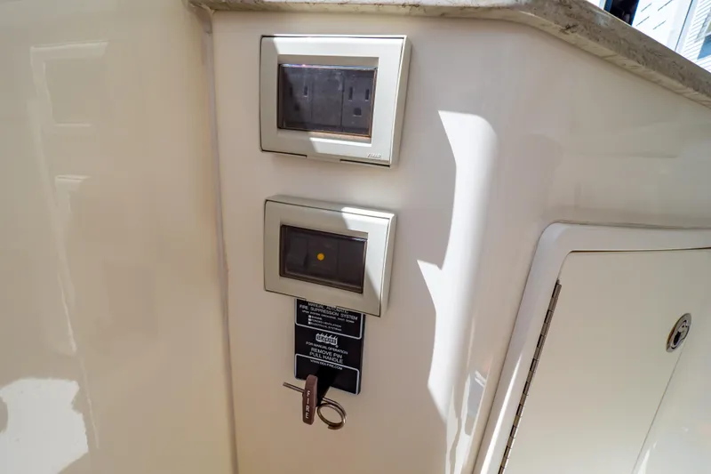 Slide: The Image of Control panel on 2019 Boston Whaler 350 Realm boat, featuring electrical outlets and fire suppression system. - 94